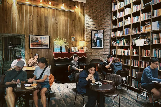 Tranquil Books & Coffee mang đến một không gian yên tĩnh với những kệ sách lớn, ánh đèn vàng dịu và tiếng nhạc nhẹ vừa đủ để tạo cảm giác thư giãn